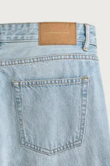 Jeans regular fit de mezclilla negra con efecto lavado, corte recto y tiro medio. Cuenta con diseño de cinco bolsillos y cierre frontal con cremallera y botón.