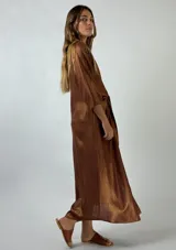 Vestido midi plateado brillante, tipo camisa, con cuello clásico, mangas 3/4 y lazo en la cintura.