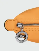 Mochila de cuero de diseño minimalista con solapa frontal, cierre de botón a presión y correas ajustables. Cuenta con asa superior y estructura compacta.