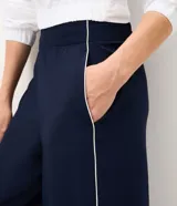 Pantalón deportivo de microfibra color verde, de corte recto y cintura elastizada, con línea lateral en contraste.