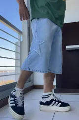 Bermuda de jean celeste, corte ancho y largo a la rodilla, con aplique de estrella en el lateral.