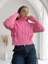 Sweater rosado de punto con cuello alto, mangas largas y diseño con roturas.