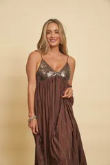 Vestido largo marrón con tirantes finos, escote en V y corte imperio. El corpiño está decorado con lentejuelas brillantes y la falda larga presenta líneas de abalorios y detalles bordados en vertical.