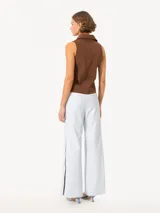 Pantalon de cuero de corte ancho y tiro medio, con cintura elástica y detalle de botones a presión en los laterales de las piernas.