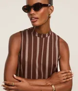 Vestido midi evasé sin mangas, confeccionado en viscosa, con cuello alto, corte en la cintura, recortes fruncidos en la pollera y rayas verticales desencontradas.