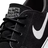 Championes Nike SB Zoom Janoski de perfil bajo, color negro con el logo de Nike en blanco en el lateral y suela de goma blanca vulcanizada.