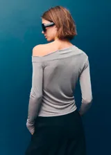 Camiseta de manga larga con diseño entallado, cuello asimétrico y detalle fruncido en el hombro.