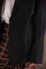 Blazer negro de corte clásico con cierre frontal de un botón y detalle de bordado ornamental a tono en el lateral. Posee un largo a la cadera.