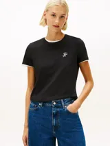 Remera de corte regular y manga corta de color negro, con cuello redondo y detalles en blanco en cuello y mangas. Cuenta con logo script de Tommy Hilfiger bordado en el pecho.
