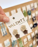 Aros abridores en forma de flores dobles, combinando tonos beige y marrón con centro detallado.