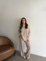 Conjunto de dos piezas compuesto por una remera de manga larga y un pantalón de corte recto, ambos confeccionados en tejido de punto texturizado color marrón.