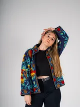Chaqueta corta azul marino con bordados florales multicolores.