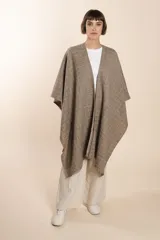 Ruana de lana fina color crudo con terminación envivada.
