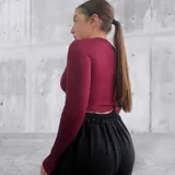 Remera blanca de tejido de punto acanalado, con cuello alto y abertura en el pecho.