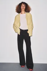 Jeans de tiro bajo, pierna ancha y largo completo, color negro. Presenta cinco bolsillos y cierre frontal con cremallera y botón metálico.