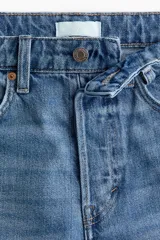 Bermuda de cinco bolsillos en denim de algodón, de tiro alto con cierre de botones y detalles de roturas.