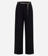 Pantalón wide leg negro de crepé con caída recta, cintura con pasadores y cinto de cadena metálica fina con dije frontal colgante.