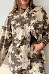 Sobrecamisa de corte oversize con estampado animal print abstracto en tonos marrón y beige, cierre frontal de botones metálicos y bolsillos appliqués en el pecho.