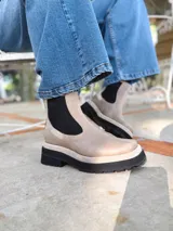 Botas Chelsea color visón de cuero con elástico lateral negro, suela track y tirador trasero.