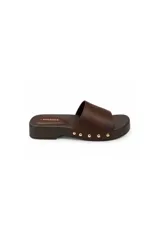Sandalias tipo zueco marca Paddock, color marrón, con suela plana de plataforma baja, tira ancha en el empeine decorada con tachas doradas laterales.