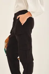 Pantalon tipo cargo color negro, de corte holgado, con bolsillos laterales y en las piernas. Posee cierre y botones en el frente, cintura elástica y puños elásticos en el ruedo.