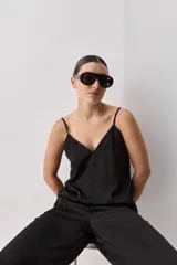 Top negro de breteles finos con escote en V y diseño minimalista, confeccionado en tela fluida y suave.