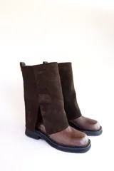 Bota de cuero negra con caña alta y detalle volcado en la parte superior. Taco bajo y puntera redondeada.