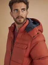 Campera puffer verde militar con capucha, cierre frontal, bolsillos laterales con cierre y un bolsillo de solapa en el pecho.