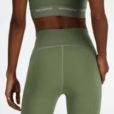 Calza deportiva verde oliva de tiro alto, confeccionada con tejido NB Sleek que se adapta a la silueta y ofrece libertad de movimiento. Cuenta con tecnología NB DRY de secado rápido, bolsillo interior en la cintura, puño plegable en el tobillo con cinta reflectante y logo Flying NB.