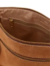 Cartera bandolera de cuero gamuza marrón camel, con detalles de cuero liso a contratono, bolsillo exterior con cierre y logo metálico dorado de la marca. Cuenta con correa regulable.