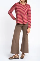 Remera de manga larga con diseño de rayas horizontales en blanco y negro, cuello redondo y corte ajustado al cuerpo.