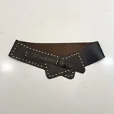 Cinto faja ancho de cuero genuino color marrón oscuro, con diseño estructurado y decorado con tachas metálicas doradas. Cuenta con cierre de hebilla metálica y diseño artesanal de inspiración ecuestre.