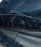 Pantalón de jean modelo flare, de tiro alto, con cierre frontal de botones a la vista y bolsillos funcionales.