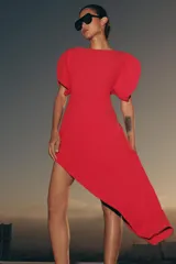 Vestido midi de cuello barco y manga corta abullonada, color rojo, con diseño asimétrico en el bajo en línea evasé y cierre trasero con cremallera oculta.