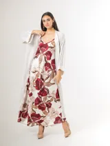 Vestido largo de satén azul marino con tirantes finos y escote en V, con gran estampado floral en tonos blancos, celestes y marrones, y diseño de caída fluida.