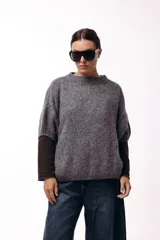 Sweater de tejido de punto grueso con silueta amplia y mangas 3/4. Presenta un diseño de calce relajado con cuello redondo y textura voluminosa.