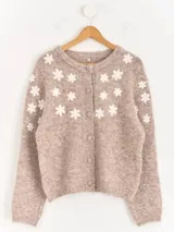 Cardigan de punto color beige con flores blancas bordadas, cuello redondo y cierre frontal con botones forrados.