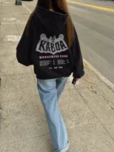 Canguro de felpa gris melange con capucha, manga larga y estampa trasera de estilo rockero con tipografía y calavera.