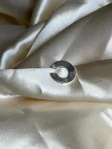 Aro earcuff plateado, con forma de C abierta y diseño minimalista.