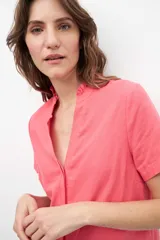 Blusa fucsia de lino con cuello mao y volados, corte recto y mangas cortas.