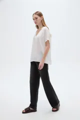 Blusa blanca de poliéster de corte holgado, con escote en V y mangas cortas.
