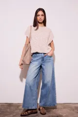 Chaleco de punto color crema con detalles en rosa y celeste, de corte holgado y mangas cortas.