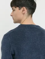 Sweater de tejido de punto con escote redondo y manga larga, con detalles de costuras en sisas y cuello. Presenta un diseño clásico y versátil.
