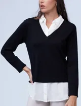 Buzo combinado con torso de tejido de punto fino en color negro y detalles de cuello y ruedo en gasa blanca que simulan una camisa debajo. Presenta escote en V y mangas largas.
