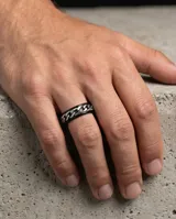 Anillo de acero con diseño central de cadena plateada y bordes negros, estilo moderno y masculino.