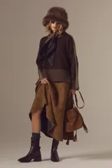 Bota tipo chelsea de cuero charolado color bordó, con caña media, elásticos laterales negros y taco cuadrado bajo.