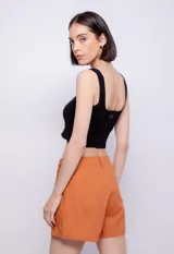 Short negro de lino y viscosa, corte holgado, con presillas, pinzas, bolsillos laterales y cierre con botón.