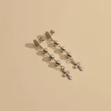 Caravanas colgantes de plata 925 con diseño de rosario, compuestas por una medalla de la Virgen Milagrosa en el tope, una cadena con esferas metálicas y un dije de cruz en el extremo.