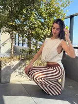 Pantalón de tejido de punto con diseño de rayas verticales en color marrón y beige, de tiro medio y corte recto y holgado.