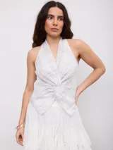 Top halter blanco con estampado a cuadros grises, escote cruzado y nudo frontal.